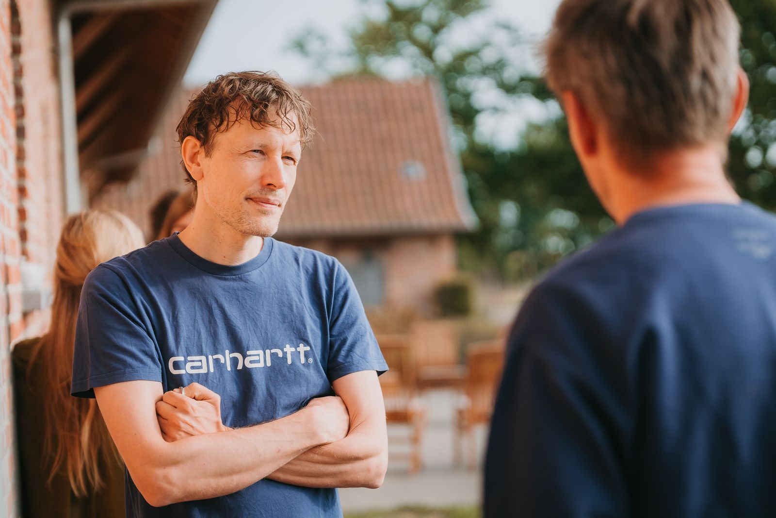 Jeroen Van Hove luistert naar iemand tijdens een gesprek buiten